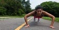 Fit young woman doing push-ups outdoors