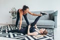 Fit young woman doing stretching exercises with the help of personal trainer at home Royalty Free Stock Photo