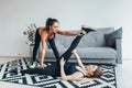 Fit young woman doing stretching exercises with the help of personal trainer at home Royalty Free Stock Photo