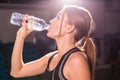 Fitness young woman drinking water in the gym. Muscular woman taking break after exercise Royalty Free Stock Photo