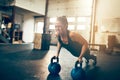 Fit young woman straining to do pushups with weights