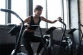 Fit young woman using exercise bike at the gym. Fitness female using air bike for cardio workout at gym Royalty Free Stock Photo