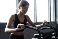 Fit young woman using exercise bike at the gym. Fitness female using air bike for cardio workout at gym Royalty Free Stock Photo