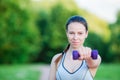 Fit young woman working out with weights outdoors. Active girl working out with small dumbbells in the park Royalty Free Stock Photo