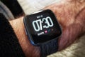 Fitbit Versa smartwatch on a man`s arm Royalty Free Stock Photo