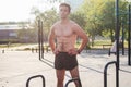 Fitnes man posing on street fitness station showing his muscular body