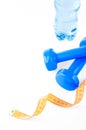 Fitnes symbols - blue dumbbells, a bottle of water and a towel. The concept of a healthy lifestyle