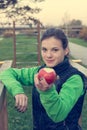 Fitnes trainer offering an apple at outdoor gym.