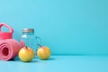 Fitness accessories on blue background: apples, water bottle, mat, free space for text