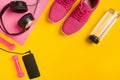 Fitness accessories on yellow background. Sneakers, bottle of water, headphones and smart. Royalty Free Stock Photo