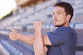 Fitness, arms and man stretching in stadium for race, marathon or competition training for health. Sports, energy and Royalty Free Stock Photo