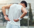 Fitness, back pain and man in city for running, workout or cardio with hurt, bruise or problem. Sports, injury and male