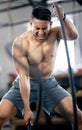 Fitness, battle ropes or strong man training for body goals in painful workout or exercise at a sports gym. Resilience Royalty Free Stock Photo