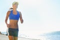 Fitness, beach and young woman running for race, competition or marathon training exercise. Sports, health and female Royalty Free Stock Photo