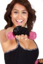 Fitness: Beautiful and very athletically fit woman curls dumbbells with a winning smile.