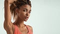 Fitness beauty. Close up of beautiful young african woman in sportswear holding her hair in hand and looking at camera Royalty Free Stock Photo