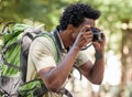 Fitness, black man and hiking with camera, forest and tourism in nature, capture moment and wilderness. African American