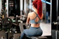 Fitness and bodybuilding concept - Fit active woman in the gym using gym machines, working out back muscles Royalty Free Stock Photo