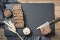 Fitness bread. A loaf of fresh rustic whole rye bread with wheat, sliced on a black slate dish board, rural food background. Top v Royalty Free Stock Photo