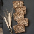 Fitness bread. A loaf of fresh rustic whole rye bread with wheat, sliced on a black slate dish board, rural food background. Top v Royalty Free Stock Photo