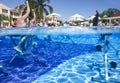 Fitness class doing aqua aerobics on exercise bikes in swimming pool resort hotel Royalty Free Stock Photo