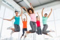 Fitness class and instructor jumping in fitness studio Royalty Free Stock Photo
