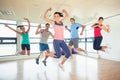 Fitness class and instructor jumping in fitness studio Royalty Free Stock Photo