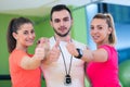 Fitness class showing thumbs up in gym