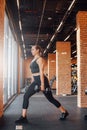 Strong female sportsperson lifting dumbell in gymnastic hall