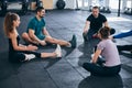 Fitness coach and his clients performing the seated forward bend