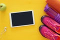 fitness concept with bottle of water, towel, tablet devise and woman pink sport footwear over colorful background Royalty Free Stock Photo