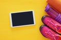 fitness concept with bottle of water, towel, tablet devise and woman pink sport footwear over colorful background Royalty Free Stock Photo