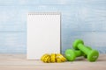 Fitness concept with dumbbells and notepad for workout plan Royalty Free Stock Photo