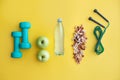 Fitness concept with dumbbells, nuts, water, bananas, apples and skipping rope on color background. Royalty Free Stock Photo