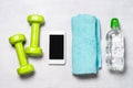 Fitness concept -dumbbells, smartphone, water.