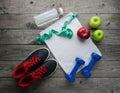 Sneakers dumbbells bottle of water apple and measure tape Royalty Free Stock Photo