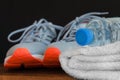 Fitness concept. Sneakers sport shoes, towel, bottle of water on wooden background