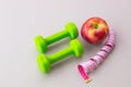 Fitness cFitness concept. Still Life red apple, green dumbbells and tape measure on background. Top view. Slimming Royalty Free Stock Photo