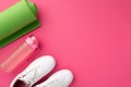 Fitness concept. Top view photo of green sports mat white shoes and pink bottle of water on isolated pink background with empty Royalty Free Stock Photo