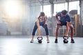 Fitness couple doing a kettlebell workout, exercise or warmup training in a gym. Fit sports people, woman and man with a Royalty Free Stock Photo