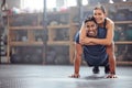 Fitness couple having fun while man does push ups and exercise together at the gym. Healthy, fit and athletic friends