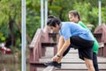 A fitness couple stretches in the park. In the morning, a young man and a young woman exercise together. After jogging, a couple Royalty Free Stock Photo