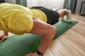Fitness. Cropped shot of a strong man fitness instructor in sportswear doing push ups on yoga mat at home Royalty Free Stock Photo