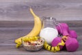 Fitness and diet concept with weights,yoghurt, muesli and banan