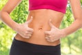 Close up of woman showing tummy and thumbs up Royalty Free Stock Photo