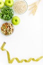 Weight loss concept with oatmeal, nuts, greenery, fruits and measuring tape on white background top view copy space Royalty Free Stock Photo