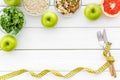 Weight loss concept with oatmeal, nuts, greenery, fruits and measuring tape on white background top view copy space Royalty Free Stock Photo