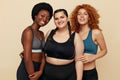 Fitness. Different Ethnicity Models Portrait. Smiling Diversity Women In Fitness Clothes Posing On Beige Background.