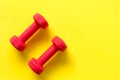 Fitness dumbbell sports equipment top view, yellow color background.