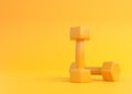 Fitness dumbbells pair. Two yellow color rubber or plastic coated dumbbell weights on yellow background